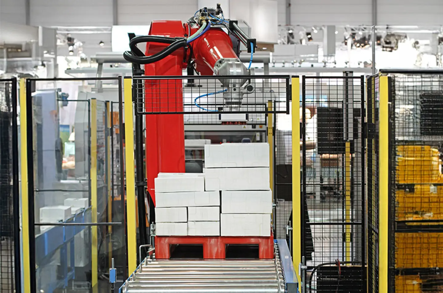 Industrial conveyor system in a factory with safety barriers with warning stripes on the floor