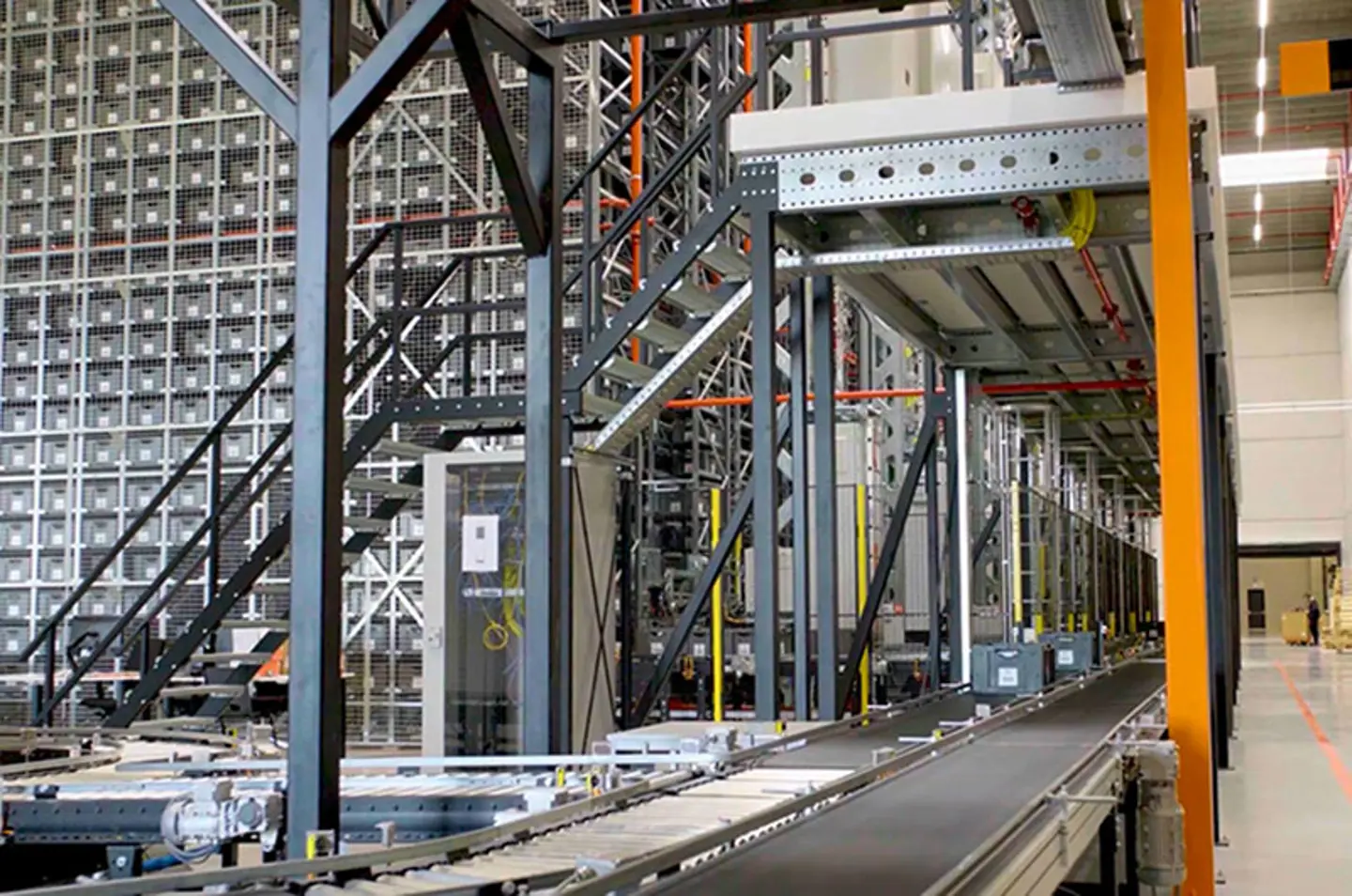 Safety fencing and guarding preventing access to hazardous machinery zones in an automated warehouse